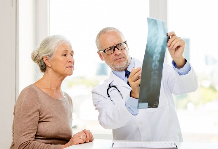 O médico diagnostica a osteocondrose cervical nun paciente mediante unha radiografía